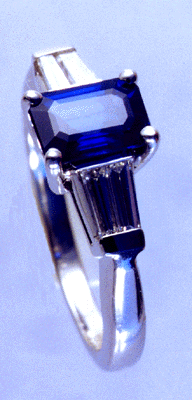 Platinum ring with emerald cut sapphire and tapered baguette diamonds.