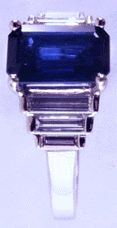 Side view of platinum ring with an emerald-cut sapphire and baguette diamonds. (J3868)